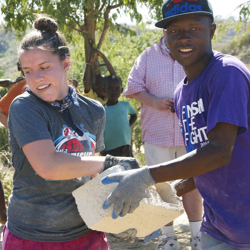 In Father Edmond Aristil’s home village of Los Palis, Chicagoan Jenna Ladner shows the face of mission in Chicago as she joins Evans Louise and other Haitians hauling cinderblocks to build community latrines. (Jason Stamps/Haiti)