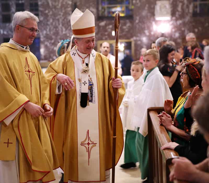 After World Mission Sunday Mass at St. Ferdinand Church, pastor Father Jason Torba and Cardinal Blase Cupich greet the congregation, including all those who do mission in Chicago. (Julie Jaidinger, Chicago Catholic/U.S.)