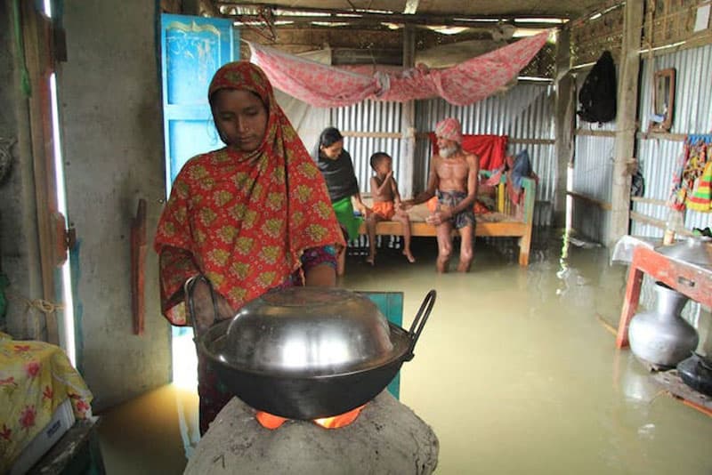 Bangladesh floods: Woman cooks food inside a flood-affected house in the Nageswari area of Kurigram district on July 14. (Liton Das, UCA News)