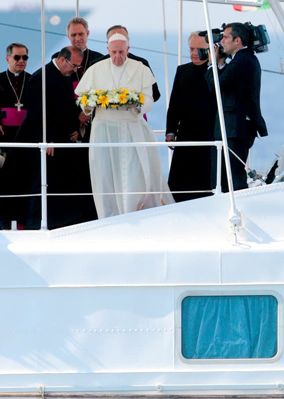 Pope Francis tosses a wreath of flowers into the Mediterranean Sea off the Italian island of Lampedusa in this July 8, 2013, file photo. The pope threw a wreath to honor the memory of immigrants who have died trying to cross from Africa to reach a new life in Europe. (CNS photo/pool)