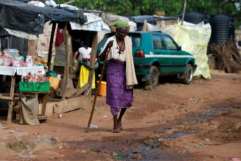 An internally displaced Nigerian woman walks with the aid of a stick in late June at a camp in Abuja. (CNS photo/Afolabi Sotunde, Reuters)