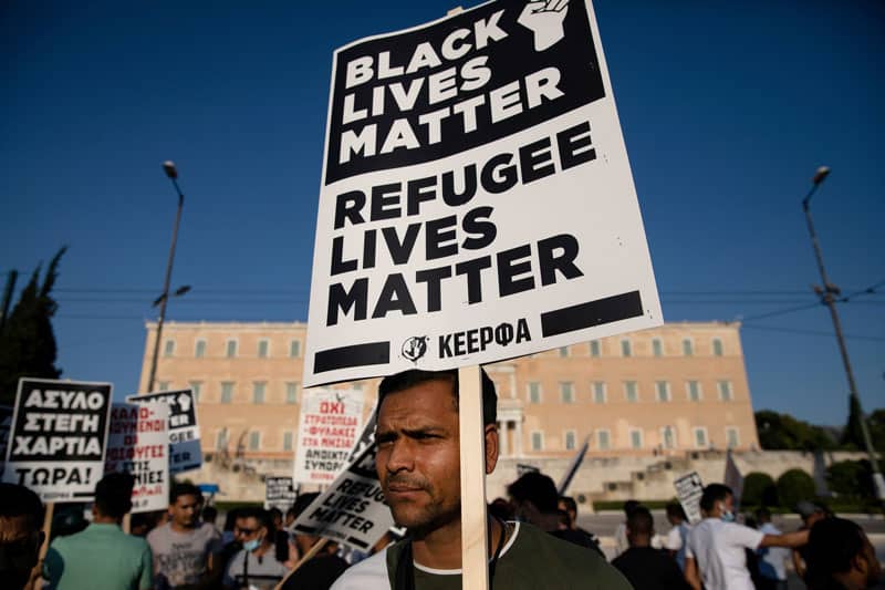 A man holds a placard reading "Black Lives Matter, Refugee Lives Matter" during a demonstration outside the Greek parliament in Athens June 26, 2020. (CNS photo/Alkis Konstantinidis, Reuters)