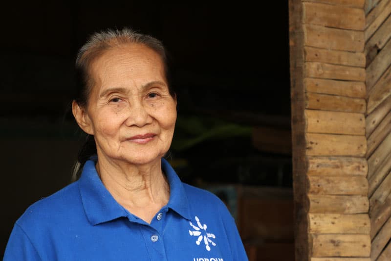 elderly lonely during pandemic: Rosalina Barra,73, stands in front of her old home in early February in Manila, Philippines, before a fire caused significant damage. Barra said while she listens to Masses on the radio, she misses the pre-pandemic times when she could "pray quietly inside the church because I feel at peace there." (CNS photo/Tristan John "Teejay" Cabrera, courtesy Unbound.org)