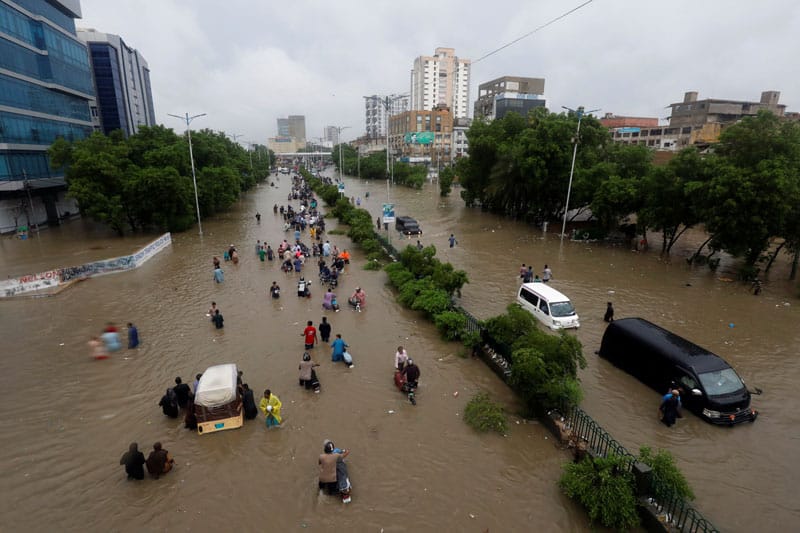 People wade through the floodwaters in Karachi, Pakistan, Aug. 27, 2020, following heavy rains. (CNS photo/Akhtar Soomro, Reuters)