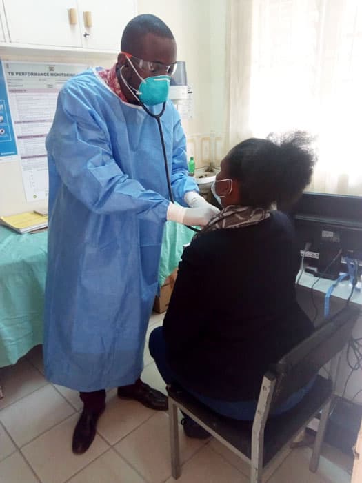 bauer-covid-19-kenya Tony Otieno, EDARP Clinical Officer, providing a clinical exam with a patient during the COVID-19 pandemic in Nairobi.