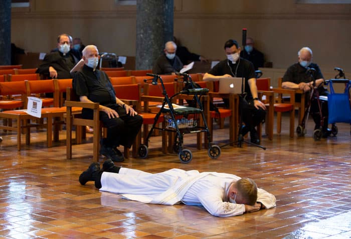 Maryknoll Father Gregory McPhee is prostrated, during the Mass of his ordination to the priesthood, while other Maryknoll priests recite the Litany of Supplication, maintaining social distance due to COVID-19. (Octavio Duran/U.S.)