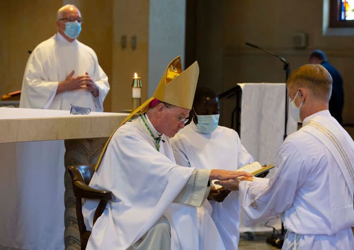 Bishop Edmund J. Whalen anoints McPhee's hands with oil at the young man's ordination to the Maryknoll missionary priesthood. (Octavio Duran/U.S.)