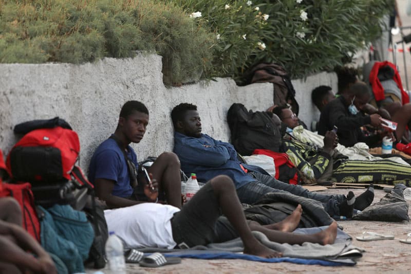 People displaced from the destroyed Moria refugee camp rest while waiting to enter a temporary camp on the Greek island of Lesbos Sept. 15, 2020. The Moria camp, which was mostly destroyed in fires Sept. 9, was home to at least 12,000 people, six times its maximum capacity of just over 2,000 asylum-seekers. (CNS photo/Elias Marcou, Reuters)