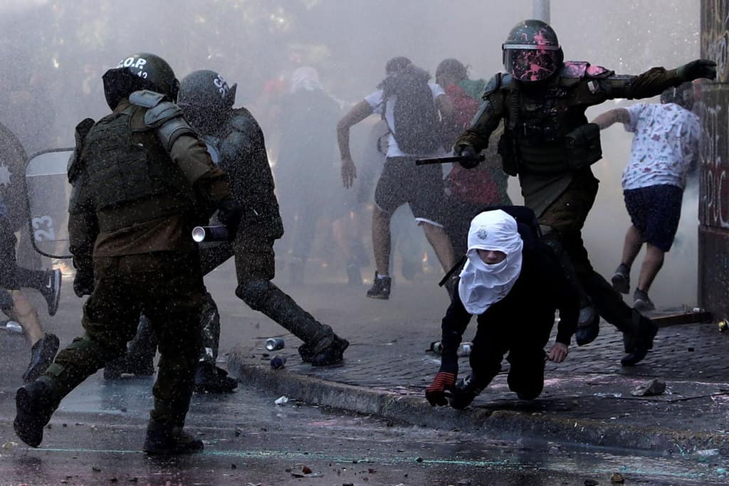 Demonstrators and riot police clash during a protest against Chile's government in Santiago Oct. 18, 2020, the one-year anniversary of the protests and riots that rocked the capital. The demonstrations occurred a week before a referendum on whether to ditch a dictatorship-era constitution. (CNS/Ivan Alvarado, Reuters)