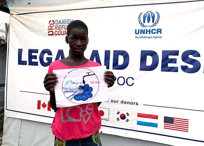 At a U.N. project on COVID-19 awareness, a youth shows her drawing of the need for handwashing to prevent the spread of the virus. (Courtesy of Michael Bassano/South Sudan)