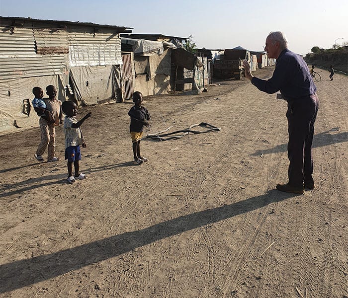 Just before COVID-19 prevented him from visiting the U.N. camp, Father Bassano maintained social distancing while greeting the children there. (Courtesy of Michael Bassano/South Sudan)