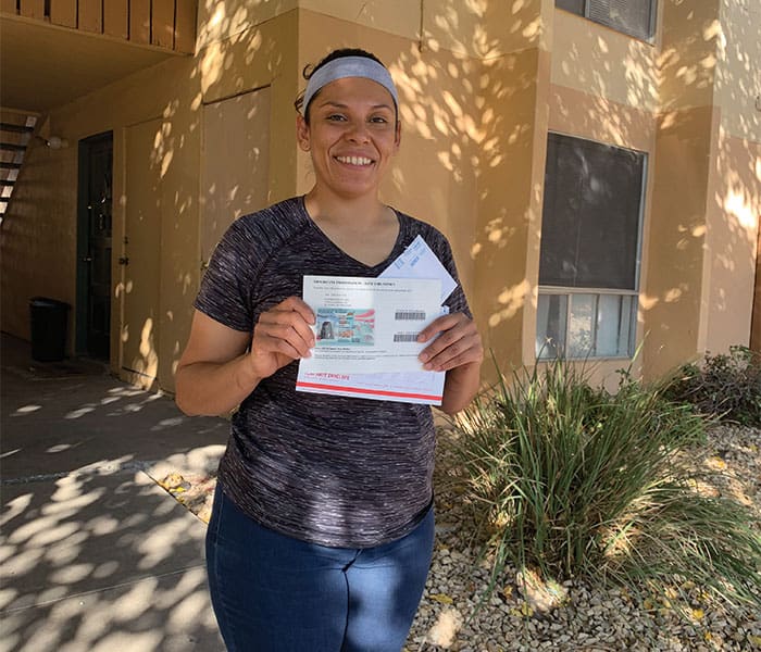 Victorious Elizabeth proudly displays her Green Card, which signifies she is legally authorized to live and work in the United States permanently. (Coralis Salvador/U.S.)