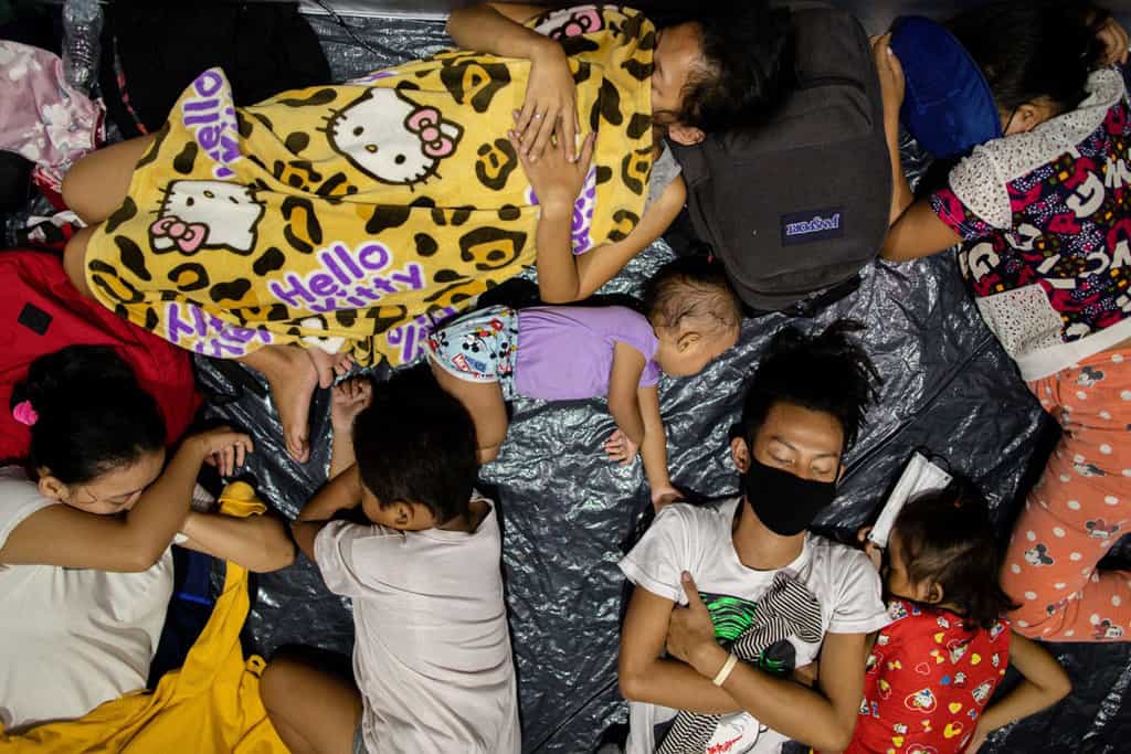 A family sleeps inside a modular tent in an evacuation center in Manila, Philippines, where residents from low-lying areas took shelter Nov. 2, 2020, following Super Typhoon Goni, also known as Rolly. The storm, whose maximum wind speeds earned it the distinction of the year's most powerful cyclone, left at least 10 people dead and three missing. (CNS/Eloisa Lopez, Reuters)