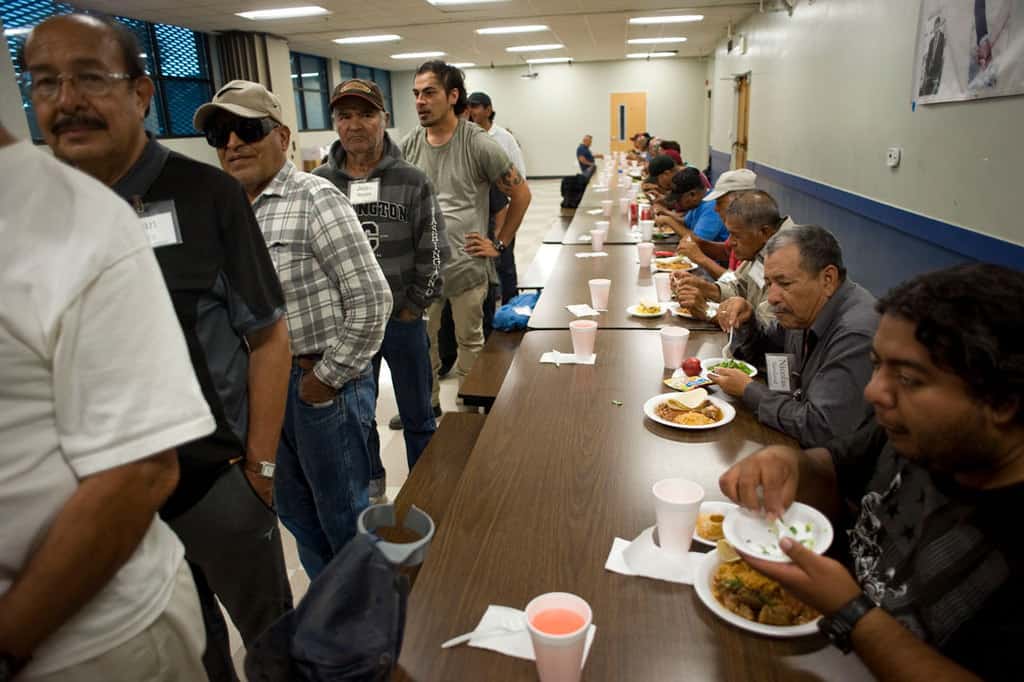 Men eat while others wait in line September 2018, at Dolores Mission Church in Los Angeles. The Jesuit-run church's Guadalupe Homeless Project provides housing and social services to homeless men and women. The project typifies the principle of Catholic social teaching on life and the dignity of the human person. (CNS/David Maung)