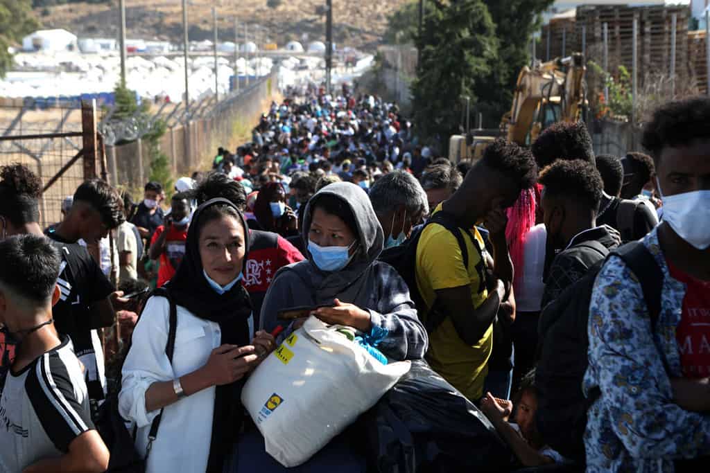 Displaced asylum-seekers from the destroyed Moria refugee camp on the Greek island of Lesbos line up to board a ferry to the mainland Sept. 28, 2020. (CNS/Elias Marcou, Reuters)