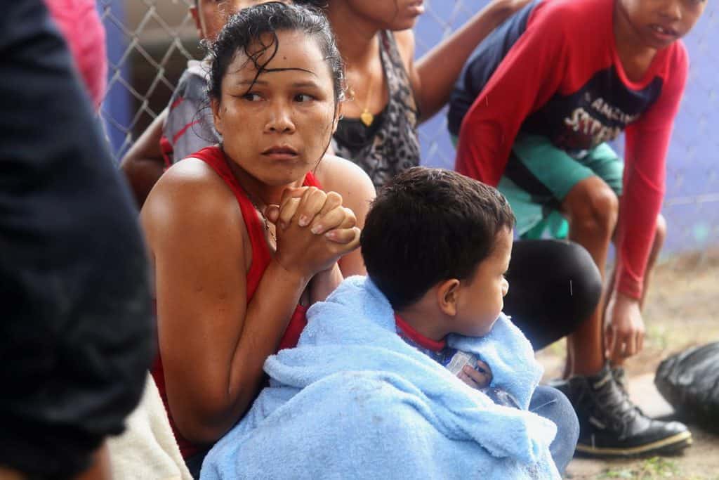 Venezuelan migrants warm themselves after arriving on shore at Los Iros Beach in Erin, Trinidad and Tobago, Nov. 24, 2020. After a different boat carrying refugees was allegedly denied entry into Trinidad and Tobago and subsequently shipwrecked, Venezuelan bishops said the treatment of migrants fleeing the country constitutes serious human rights violations. (CNS photo/Lincoln Holder, Newsday handout via Reuters)