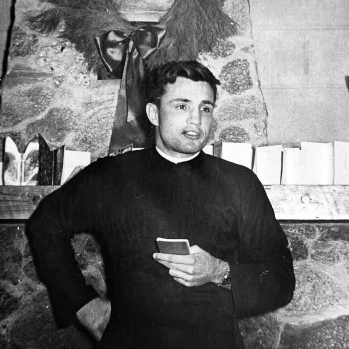 T-19jp223 In this photo circa 1953, young Jim Jackson stands in front of the fireplace at the Maryknoll novitiate in Bedford, Massachusetts, where he was a student preparing for missionary priesthood. (Courtesy of James Jackson/U.S.)