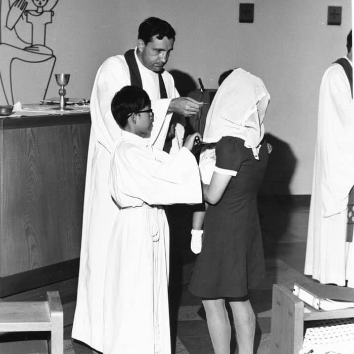 Father James Jackson gives first Communion to a newly Baptized woman at Suzuka Catholic Church around 1970. (Maryknoll Mission Archives)