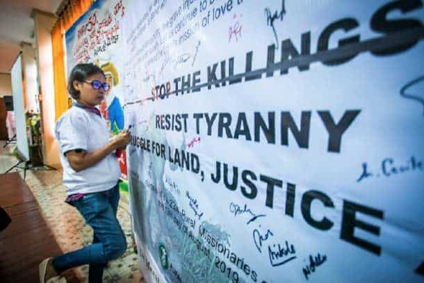 Zara Alvarez, an activist from Negros province in the central Philippines, signs a manifesto signifying her commitment to work for human rights in this August 2019 file photo. Alvarez was shot dead in Bacolod City on Aug. 17, 2020. (Photo: Mark Saludes)