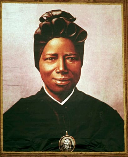 A tapestry of St. Josephine Bakhita, an African slave who died in 1947, hangs from the facade of St. Peter’s Basilica during her canonization in 2000 at the Vatican. Pope Francis released a video message marking the International Day of Prayer and Awareness against Human Trafficking, which is celebrated on the Feb. 8 feast of St. Bakhita. (CNS photo/L’Osservatore Romano via Reuters)