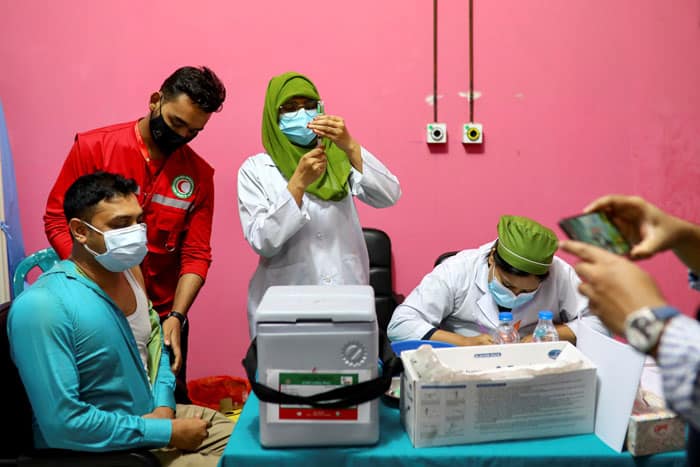 A man waits to get vaccinated with an injection of the Oxford-AstraZeneca COVID-19 vaccine at the Dhaka Medical College vaccination center in Dhaka, Bangladesh, Feb. 9, 2021. (CNS photo/Reuters)