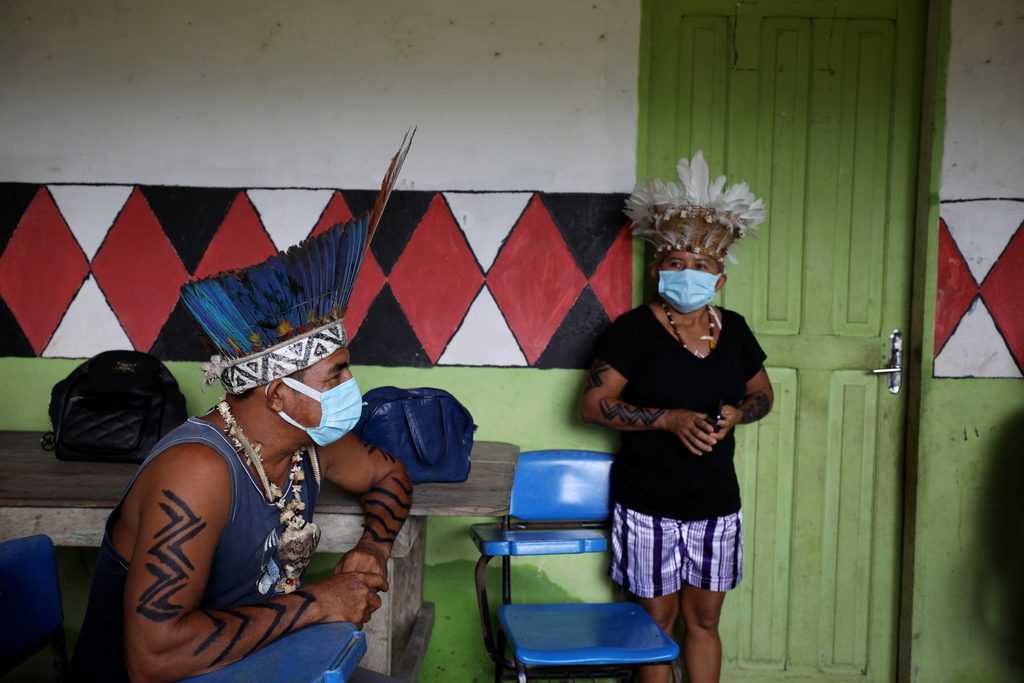 BRAZIL INDIGENOUS COVID-19 VACCINE Indigenous people wait to receive the Sinovac's CoronaVac COVID-19 vaccine in the village of Itacoatiara, Brazil, Feb. 13, 2021. The Brazilian bishops' conference has come under fire from some of its more conservative members since it announced this year's Fraternity Campaign, which defends Indigenous peoples, criticizes the high rates of femicide and speaks up against LGBTQ violence and homophobia. (CNS photo/Bruno Kelly, Reuters)