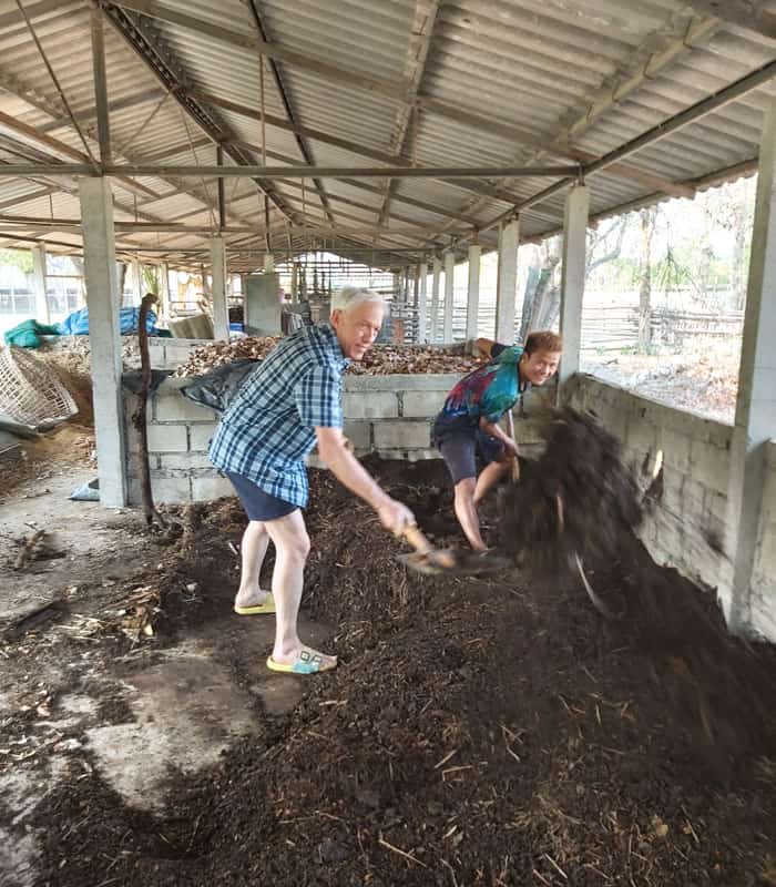 Father Radice (left) and Somboon, a student of the Lahu ethnic group, work on composting. (Courtesy of Lawrence Radice/Thailand)