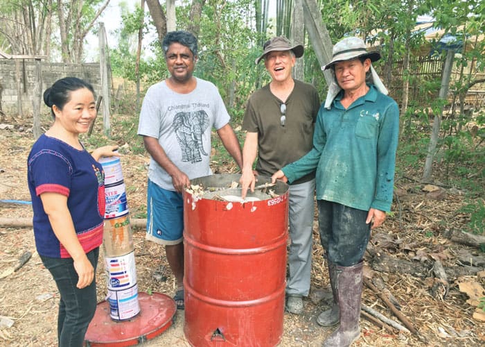 Staff members of RTRC (l. to r.) Ms. Phut, Mr. Sornchai, Father Radice and Mr. Manut make biochar by burning organic waste material. (Courtesy of Lawrence Radice/Thailand)