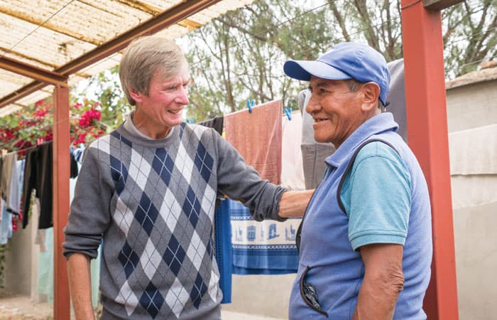 O’Donoghue walks around the home to check on the patients. Here he is talking and joking with Justo in the outside washing area at the center. (NIle Sprague/Bolivia)