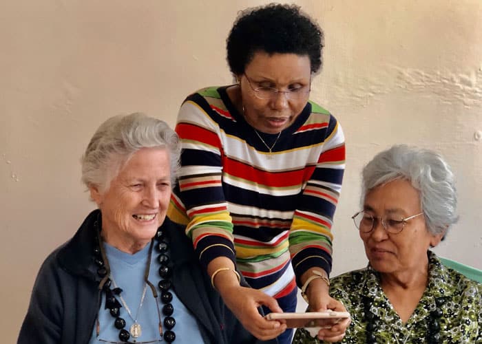 Sister Bitrina Kirway demonstrates the marvels of the smartphone to her Maryknoll Sister companions Ardis Kremer (left) and Rosalinda Barrozo. (Courtesy of the Maryknoll Sisters)