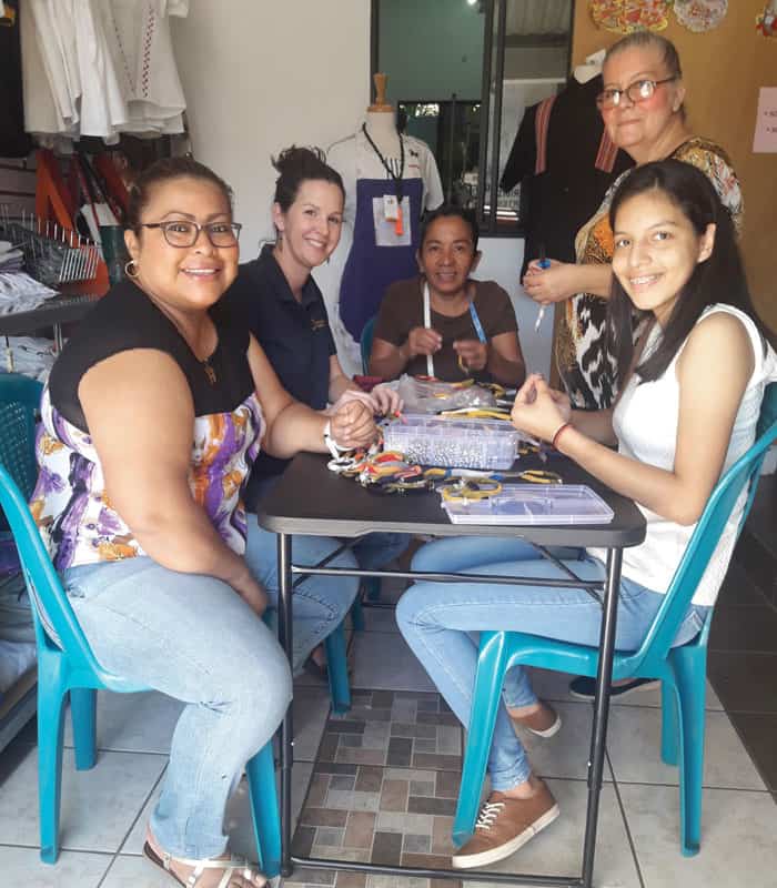 A youth joins Acomujerza co-op members at a bracelet-making workshop. (Rafael Borja/El Salvador)