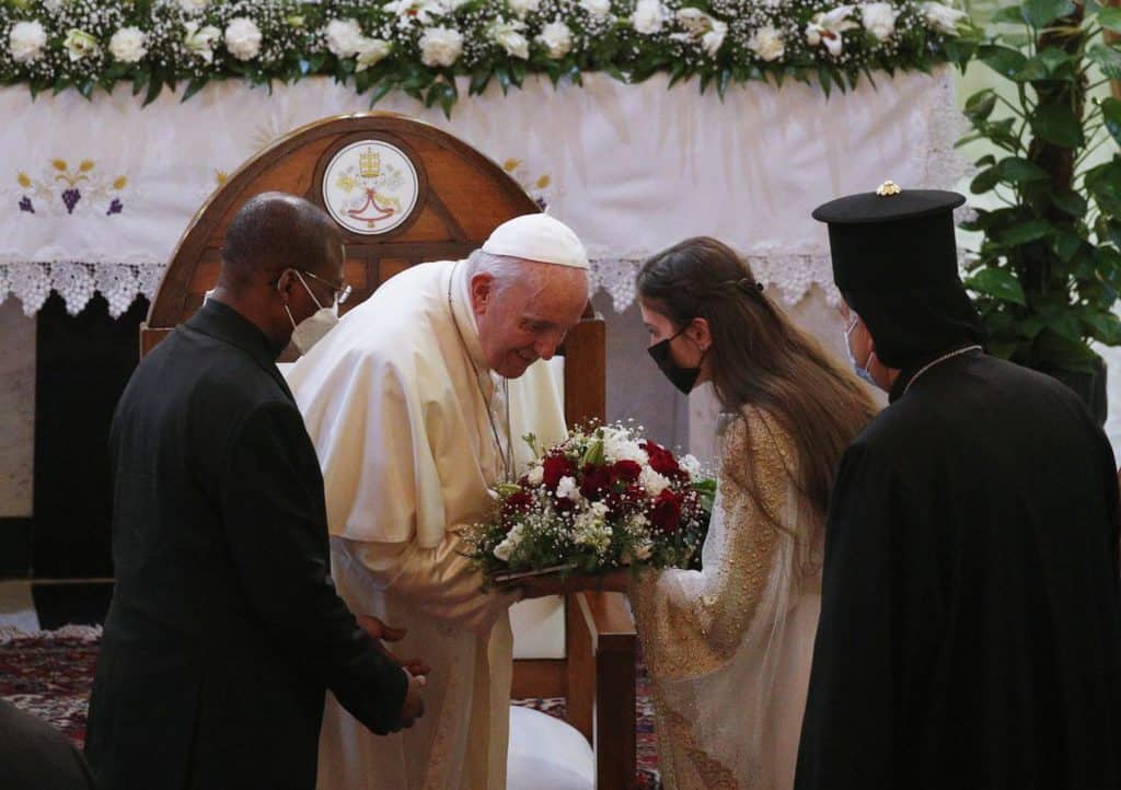 Pope Francis accepts flowers during a meeting with bishops, priests, religious men and women, seminarians and catechists in the Syriac Catholic Cathedral of Our Lady of Deliverance in Baghdad, Iraq, March 5, 2021. (CNS photo/Paul Haring)