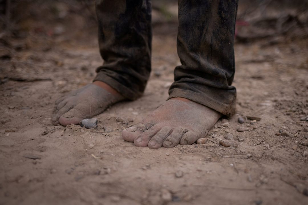 A migrant's bare feet are seen in La Joya, Texas, March 14, 2021, after the migrant crossed the Rio Grande River. (CNS photo/Adrees Latif, Reuters)