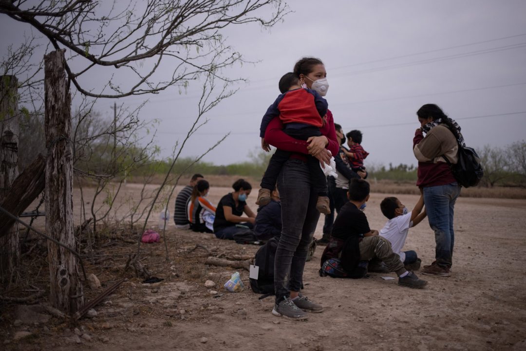 An 18-year-old Honduran mother holds her son after crossing the Rio Grande River into La Joya, Texas, March 14, 2021. (CNS photo/Adrees Latif, Reuters)
