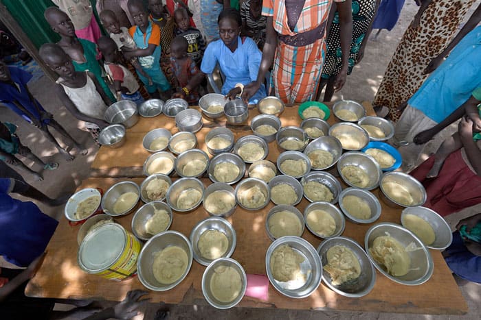 Kana Achot fills bowls with food in an emergency feeding program for malnourished children at the Loreto Girls School in Rumbek, South Sudan, April 18, 2018. Parts of Yemen, South Sudan, Burkina Faso and Nigeria are close to or already facing famine. Other countries face severe food insecurity or worse. (CNS photo/Paul Jeffrey)