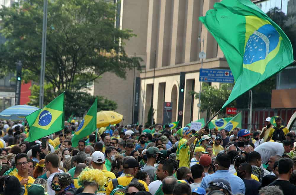 People wave Brazilian flags during a protest in São Paulo March 14, 2021, after the state government mandated further restrictions to curb the spread of COVID-19. A consortium of groups that includes the Brazilian bishops' conference has asked Brazilians, especially young people, not to be in denial about the existence of the pandemic. (CNS photo/Carla Carniel, Reuters)