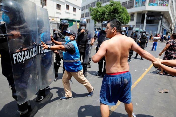 Protesters and street vendors argue with riot police over new government restrictions in Lima, Peru, Feb. 1, 2021, during the COVID-19 pandemic. (CNS photo/Sebastian Castaneda, Reuters)