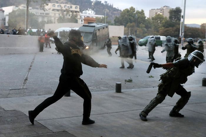 A riot policeman uses pepper spray on a demonstrator during a protest against the Chilean government in Santiago March 19, 2021. (CNS photo/Ivan Alvarado, Reuters)