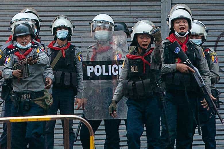 Police gesture toward protesters as security forces crack down on demonstrations against the military coup in Yangon on Feb. 28. At least 18 protesters were shot dead. (Photo: Sai Aung Main/AFP)