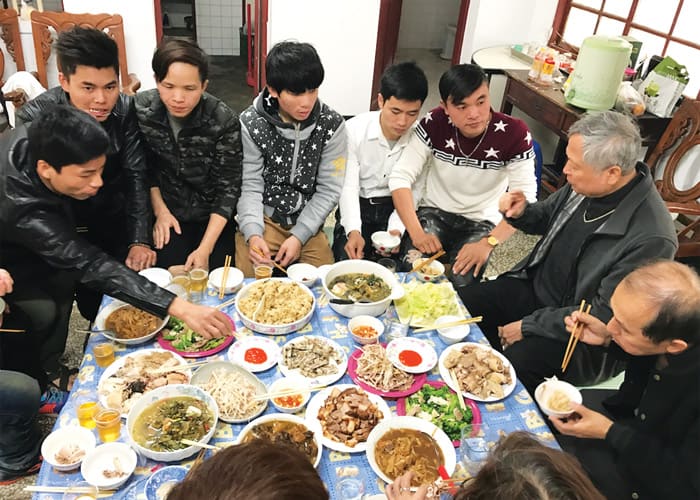 Vietnamese migrant workers share a meal with Father Nguyen after Mass, during the days the priest was working to rebuild his parish. (Courtesy of John and Justine Chu/Taiwan)