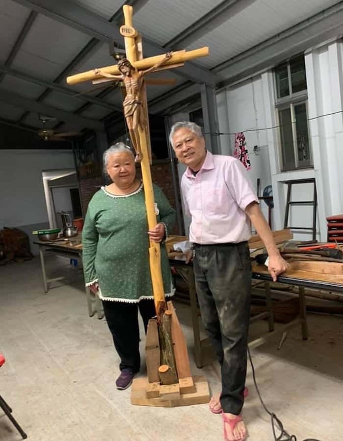 A local woman and Father Nguyen stand with a cross made by the missioner at the request of a Vietnamese priest in Taiwan. (Courtesy of Nhuan Nguyen/Taiwan)