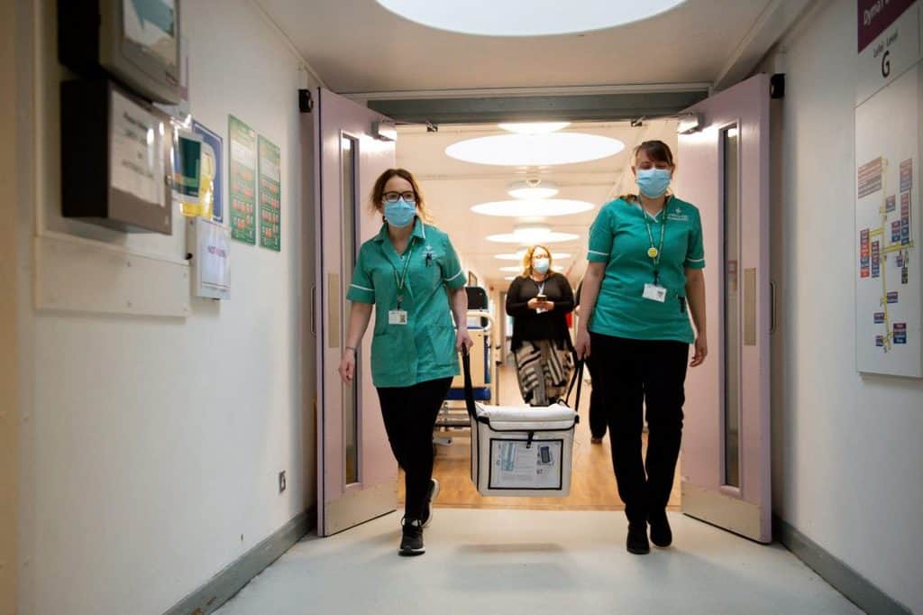 Pharmacists transport a cooler containing the Moderna coronavirus disease (COVID-19) vaccine at the Glangwili General Hospital in Carmarthen, Wales, April 7, 2021. A new Catholic coalition says vaccines need to be accessible to all. (CNS photo/Jacob King, Reuters pool)