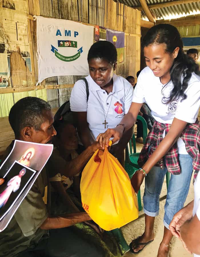 Sister Wanzagi and Divine Mercy group visit an elderly neighbor. (Courtesy of Susan Wanzagi/East Timor)