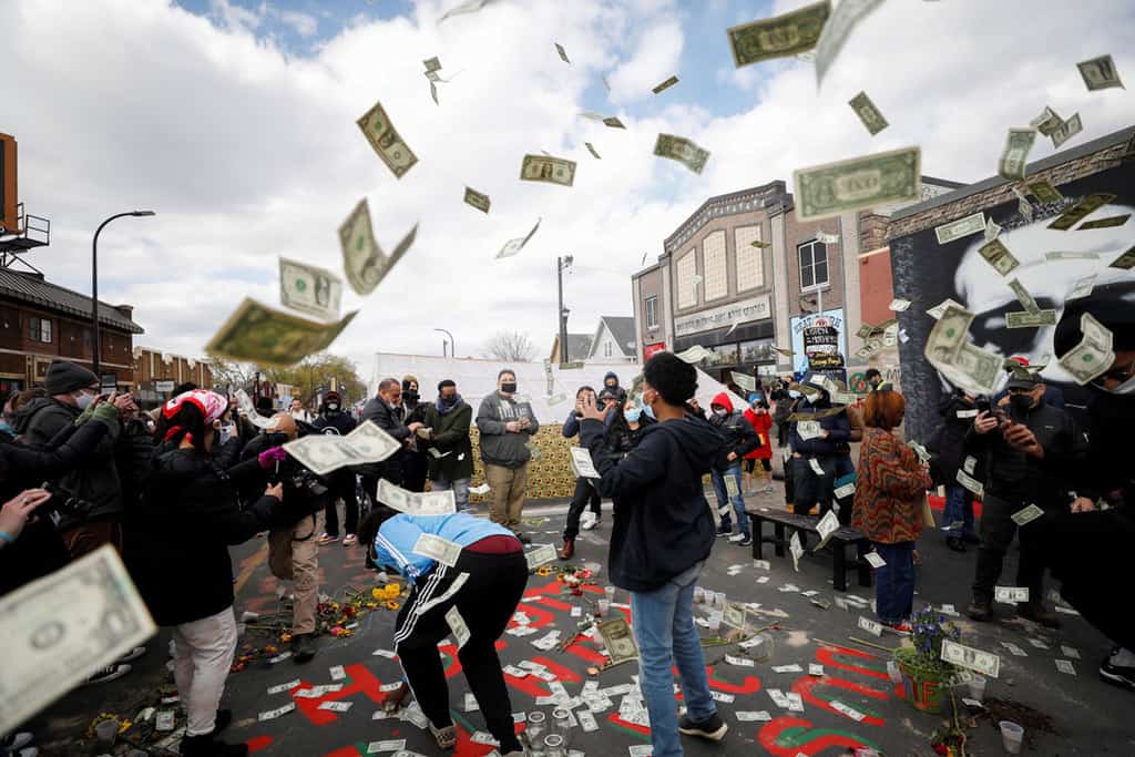 People at George Floyd Square in Minneapolis react with $1 bills April 20, 2021, after jurors issued their verdict convicting former Minneapolis police officer Derek Chauvin of second-degree unintentional murder, third-degree murder and second-degree manslaughter in the death of Floyd. (CNS photo/Octavio Jones, Reuters)