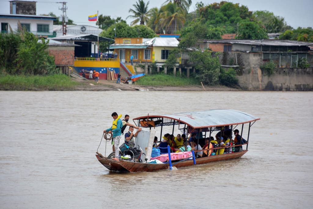 Venezuelan refugees arrive by boat in Arauquita, Colombia, April 5, 2021, after fleeing their country due to a military offensive. Church groups in Colombia are mobilizing to support thousands of Venezuelan refugees who recently fled the military offensive and are now stuck in the remote Colombian border town. (CNS photo/Reuters)