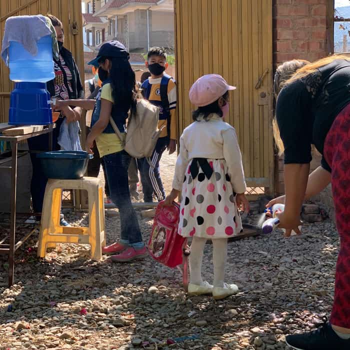 Web-Only-Sim-04 Students go through daily routine of biosecurity in Nueva Vera Cruz. The educators said that this routine became an opportunity to greet and talk with the children about their family. (Matthew Sim/Bolivia)