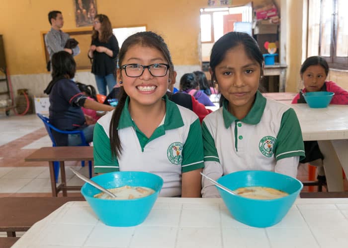 Anahi Perez (left) and Helen Pardo Vivar eat lunch at the after-school tutoring center in Cochabamba, Bolivia, before the country lockdown caused by COVID-19. (Nile Sprague/Bolivia)