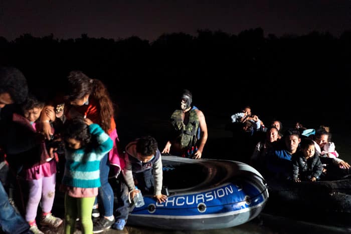 Asylum-seeking migrant families disembark from an inflatable raft in Roma, Texas, after crossing the Rio Grande April 7, 2021. (CNS photo/Go Nakamura, Reuters)