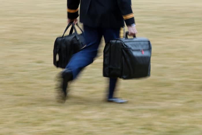 Catholics Join Scientists in Asking Biden to Seek Nuclear Disarmament: A White House military aide carries the so-called nuclear football as he walks to board the Marine One helicopter with President Joe Biden at the White House in Washington Feb. 16, 2021. (CNS photo/Jonathan Ernst, Reuters)