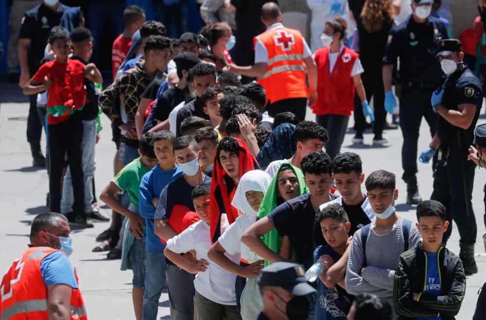 Moroccan minors line up at a facility prepared for them to rest and have food, after thousands of migrants swam across the Spanish-Moroccan border, in Ceuta, Spain, May 19, 2021. In a statement released May 18, the Spanish bishops' conference expressed concern that migrants were being exploited after a sudden of influx of refugees into the Spanish territories of Ceuta and Melilla increased tensions between Spain and Morocco. (CNS photo/Jon Nazca, Reuters)